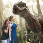 two young women meeting a tyrannosaurus rex in the forest