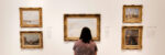 Woman looking at art exhibit hanging on the wall