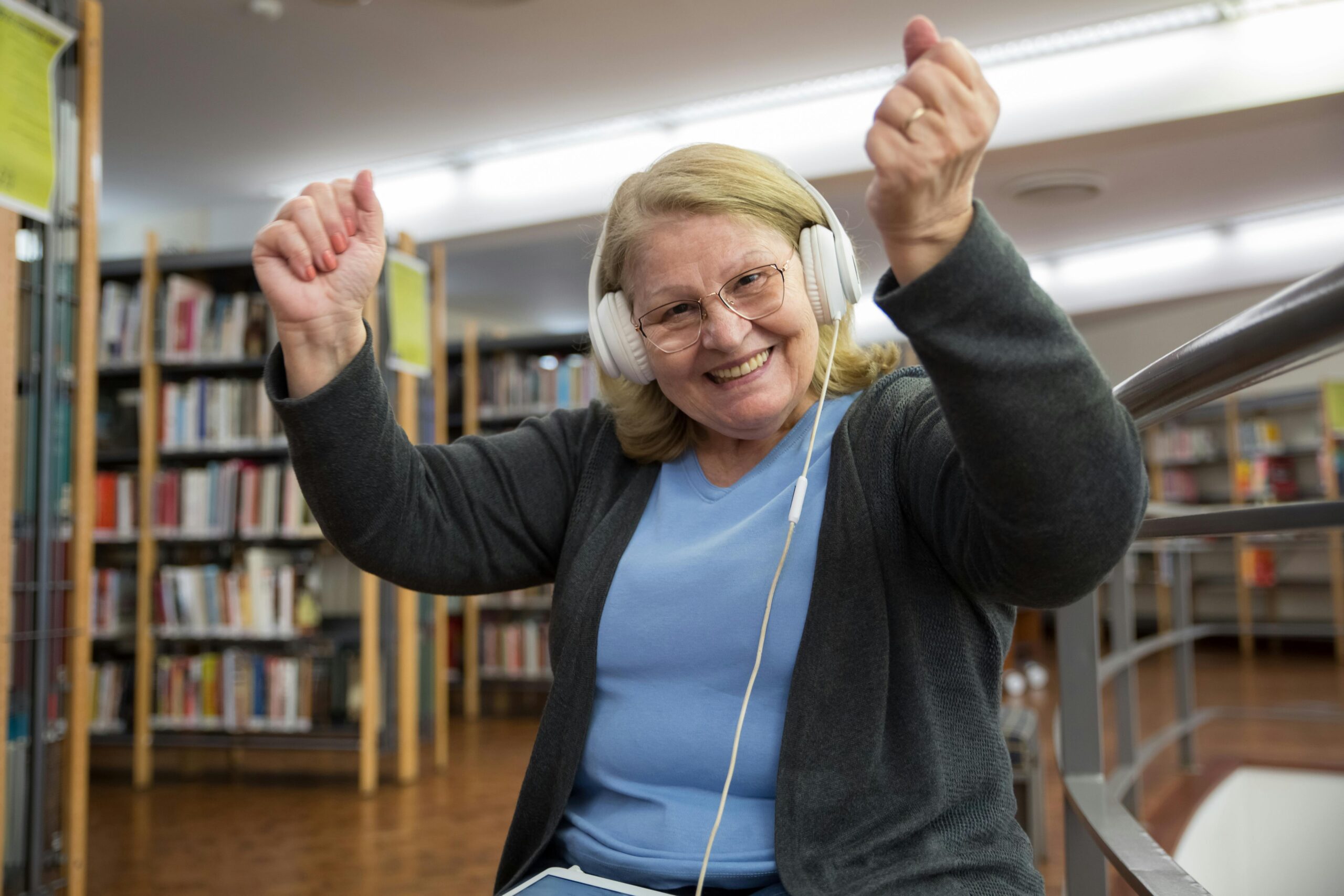 Senior listening to audio headphones at the library